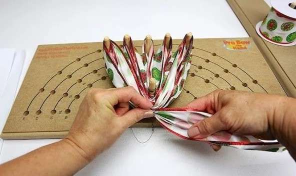 Image of hands using a bow maker for Christmas bows